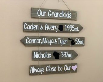 Grandkids sign with names, state maps and mileages. Grand kids directional sign wood on rope