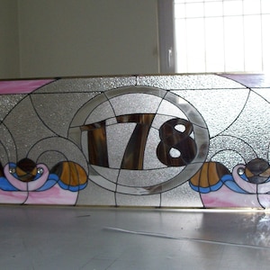Custom handcrafted stained glass transom window with a house number