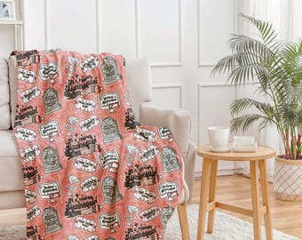 May include: A pink fleece throw blanket with a repeating pattern of tombstones and the text "It's never mannequin, you're just not creative enough".