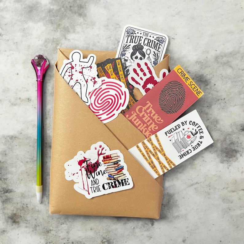May include: A brown paper envelope filled with true crime themed stickers and bookmarks. The stickers feature a fingerprint, a bloody handprint, a person with blood splatters, and a stack of books. The bookmarks feature a fingerprint, a stack of books with a bloody knife, and the text "True Crime Junkie".