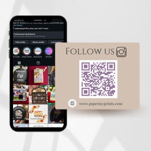 May include: A smartphone displaying an Etsy shop profile with various product images. A tan card with the text "FOLLOW US" and a QR code is in the foreground. The website address www.paperjoyprints.com is also visible.