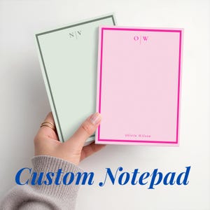 Può includere: Due blocchi per appunti rettangolari con bordi colorati. Il blocco a sinistra è verde chiaro con un bordo verde scuro e le iniziali N|V. Il blocco a destra è rosa chiaro con un bordo rosa acceso, le iniziali O|W e il nome Olivia Wilson.