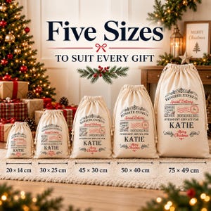 May include: Five off-white drawstring gift bags in various sizes, ranging from 20x14 cm to 75x49 cm. Each bag features a printed Reindeer Express design with the name Katie, a North Pole stamp, and Merry Christmas text in red and black ink.