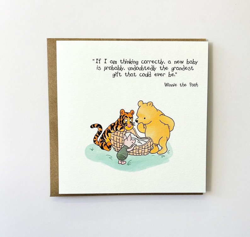 K&ouml;nnte beinhalten: Eine Winnie-the-Pooh-Illustrationskarte mit einem Zitat von Winnie the Pooh: "Wenn ich richtig denke, ist ein neues Baby wahrscheinlich, ohne Zweifel, das gro&szlig;artigste Geschenk, das man machen kann." Die Illustration zeigt Winnie the Pooh, Tigger und Ferkel, die ein Baby in einem Korb betrachten.