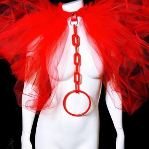 May include: Red tulle cape with a red plastic chain and ring choker.