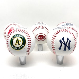 Pode incluir: Cinco rolhas de garrafa brancas com tema de beisebol com diferentes logotipos de equipe. Os logotipos são Oakland Athletics, Cincinnati Reds, New York Yankees, Boston Red Sox e um logotipo de beisebol genérico.