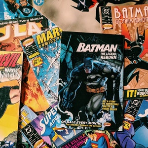 Può includere: Una collezione di fumetti con Batman, Superman e altri supereroi. Le copertine sono colorate e presentano scene d'azione. Il testo sulle copertine include titoli come "Batman: The Legend Reborn" e "Kill Kill Kill Superman".