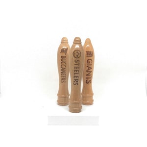 May include: Three wooden beer tap handles with team logos. The handles are engraved with the words "Buccaneers", "Steelers", and "Giants".
