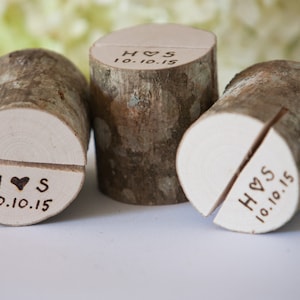 Puede incluir: Tres porta tarjetas de mesa de madera con un acabado de corteza natural. Cada porta tarjetas está dividido en dos y tiene una parte superior blanca con las iniciales "H & S" y la fecha "10.10.15" grabadas.