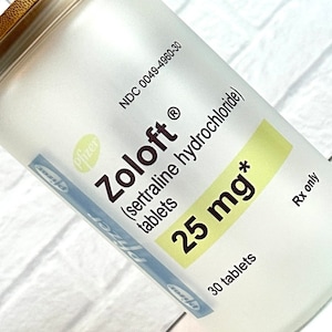 May include: A white frosted bottle with a gold lid and a label that reads "Zoloft® (sertraline hydrochloride) tablets 25 mg* 30 tablets Rx only". The label also includes the NDC number 0049-4960-30 and the Pfizer logo.