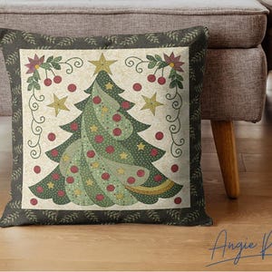 May include: A green and red Christmas tree cushion with a white background and a dark green border. The cushion features a stylised Christmas tree with red baubles and a gold star on top. The cushion is decorated with a floral design and a border of green leaves.