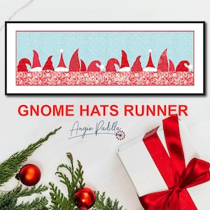 Może przedstawiać: Ramka z obrazem czerwono-białego bieżnika z motywem czapek gnomów z tekstem "Gnome Hats Runner" i "Angie Padilla" pod obrazem.