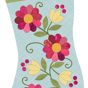 Può includere: Un calzino di Natale blu e verde con un motivo floreale. Il calzino presenta tre fiori rosa e rossi con centri gialli, foglie verdi e tulipani gialli. Il calzino è decorato con una firma bianca che dice "Angie Padilla".