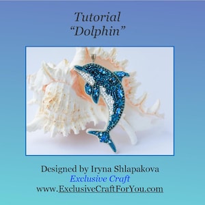 Könnte beinhalten: Ein blau-weißer, mit Perlen besetzter Delphin-Anhänger mit silberner Öse, präsentiert auf einer weißen Muschel. Das Bild enthält den Text "Tutorial Dolphin" und "Exclusive Craft".