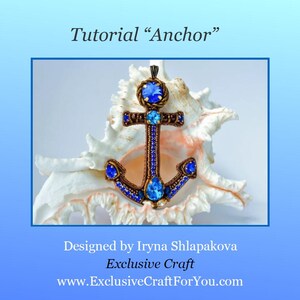 May include: A beaded anchor pendant with blue rhinestones, resting on a white seashell. The anchor is a popular nautical symbol and is often used in jewelry.
