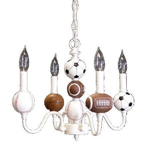 May include: White chandelier with five lights and sports ball-shaped shades. The shades are a baseball, football, soccer ball, and two basketballs.