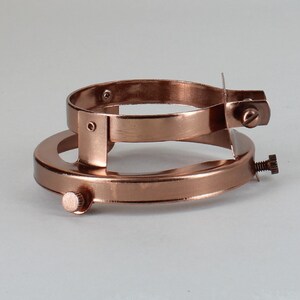 Puede incluir: Un soporte para pantallas de l&aacute;mpara de metal de color cobre con dos anillos ajustables y tres tornillos. El soporte est&aacute; dise&ntilde;ado para sujetar una pantalla de l&aacute;mpara a una l&aacute;mpara.