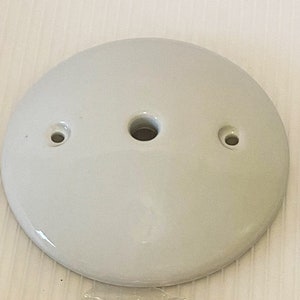 Pu&ograve; includere: Piastra per soffitto in ceramica bianca con tre fori per il cablaggio elettrico.