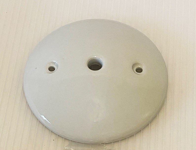 Pu&ograve; includere: Piastra per soffitto in ceramica bianca con tre fori per il cablaggio elettrico.