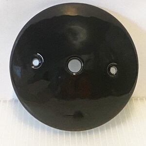 Pu&ograve; includere: Piastra da soffitto rotonda in ceramica nera con tre fori per il cablaggio elettrico.
