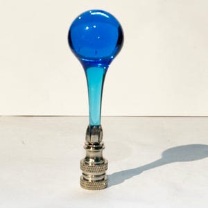 May include: A blue glass lamp finial with a round top and a silver base.