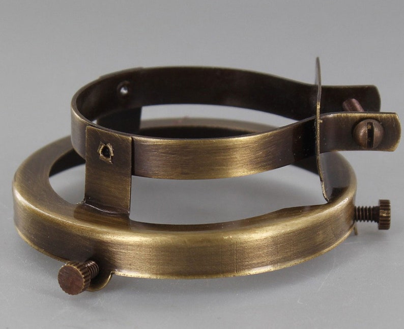 Puede incluir: Un anillo de pantalla de l&aacute;mpara de lat&oacute;n con dos tornillos en el lateral y uno en la parte inferior.