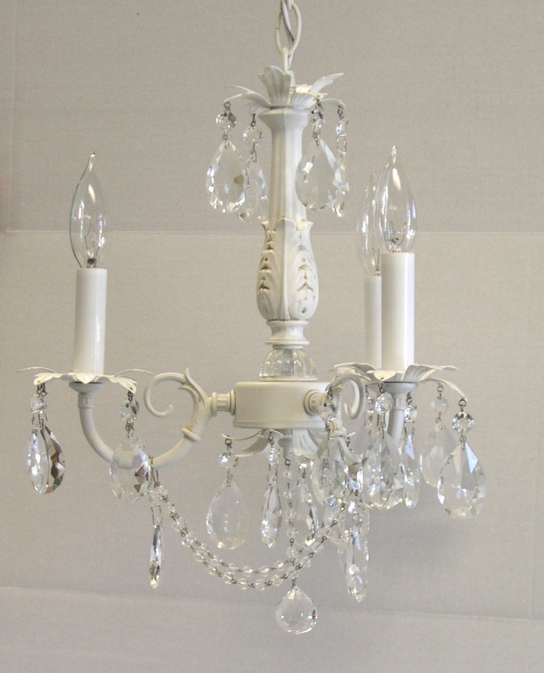 May include: White chandelier with crystal drops and candle-style light bulbs.