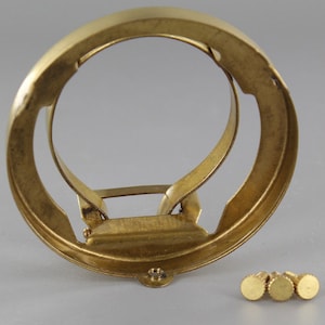 Puede incluir: Un aro de pantalla de l&aacute;mpara de lat&oacute;n con un mecanismo de resorte y tres peque&ntilde;os tornillos de lat&oacute;n.