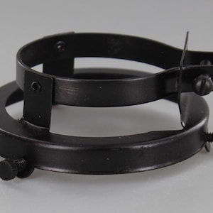 Puede incluir: Porta-pantallas de l&aacute;mpara de metal negro con dos anillos ajustables y tornillos.