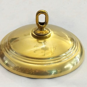 May include: A gold metal ceiling canopy with a decorative ring for hanging a light fixture.