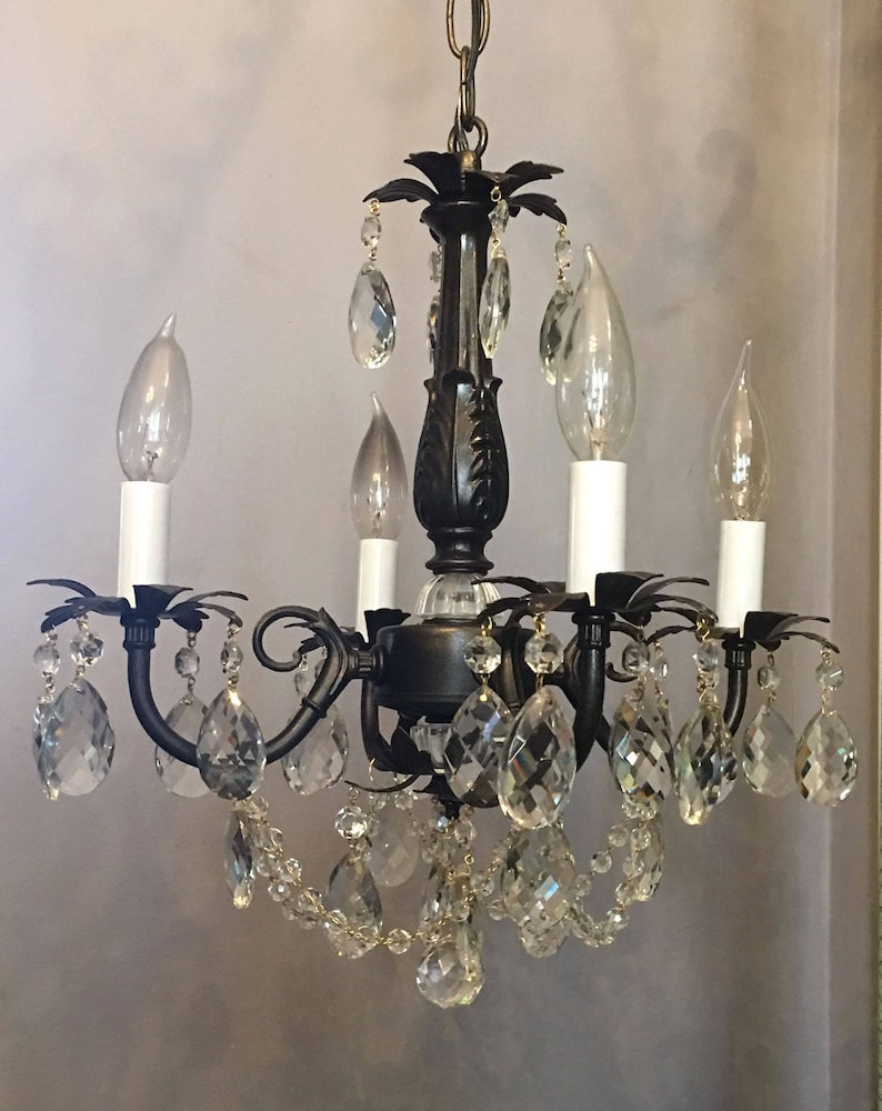 May include: A black chandelier with crystal drops and candle-style light bulbs.