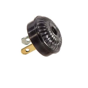 Puede incluir: Enchufe eléctrico de plástico negro de dos clavijas con una tapa redonda y nervada negra.