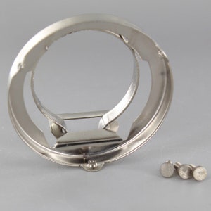 Puede incluir: Un anillo de metal plateado con un anillo m&aacute;s peque&ntilde;o en su interior. El anillo est&aacute; dise&ntilde;ado para sujetar una bombilla. Se incluyen tres peque&ntilde;os tornillos plateados.