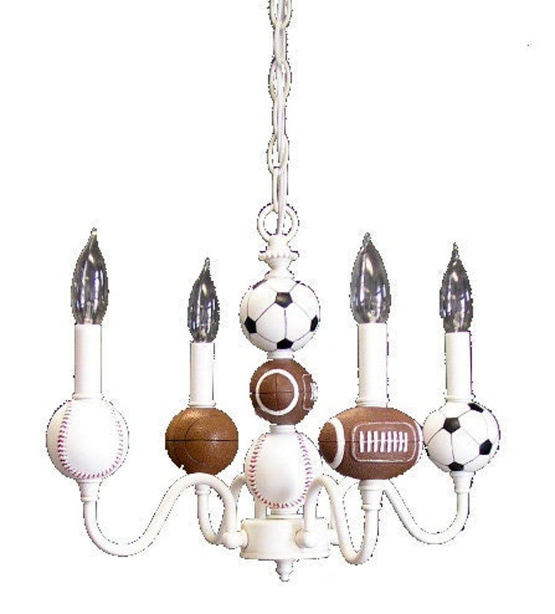 May include: White chandelier with five lights and sports ball-shaped shades. The shades are a baseball, football, soccer ball, and two basketballs.