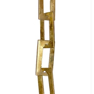 May include: A vertical chain of interlocking, rectangular links. The links are made of a gold-colored metal with a slightly distressed finish. The chain is against a white background.