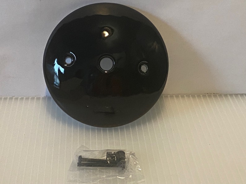 Pu&ograve; includere: Piastra da soffitto rotonda nera con tre fori per viti e un foro centrale. La piastra &egrave; inclusa con due viti nere in una busta di plastica.