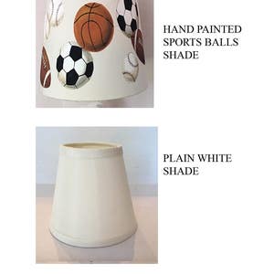 May include: Two lampshades, one plain white and the other with hand-painted sports balls. The sports balls include a basketball, baseball, soccer ball, and football.