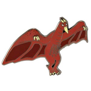 May include: Red enamel pin of a flying dinosaur with a long beak and sharp claws. The dinosaur has a speckled red body and wings.