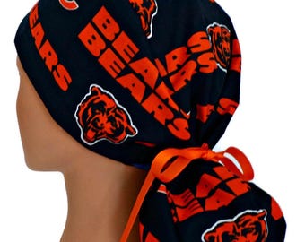 May include: Black and orange Chicago Bears scrub cap. The cap features the team's logo and the word "BEARS" in orange. The cap is tied with an orange ribbon.