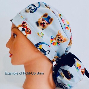 A mannequin head wearing a white cap with a pattern of dogs and cats printed on it.