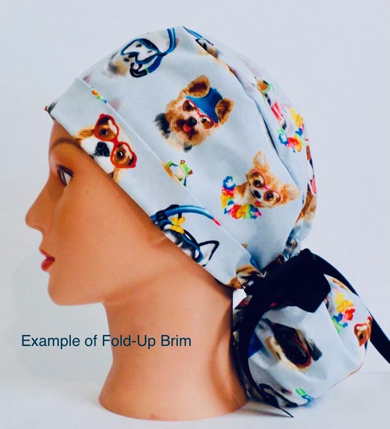 A mannequin head wearing a white cap with a pattern of dogs and cats printed on it.