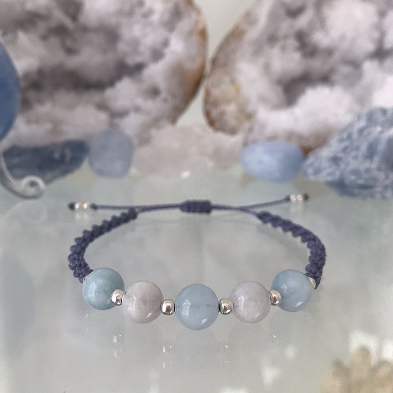 May include: A blue and white beaded bracelet with silver beads and a dark blue cord.