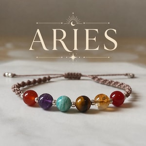 May include: A bracelet for Aries, featuring a series of colourful gemstone beads, including red, purple, turquoise, brown, and yellow. The bracelet is strung on a brown cord with adjustable ends. The word "ARIES" is displayed above.
