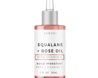 Può includere: Una bottiglia di vetro trasparente con un tappo argentato e un contagocce, contenente un liquido rosa. La bottiglia è etichettata "SABONI SQUALANE + ROSE OIL WITH VITAMIN C HUILE HYDRATANT ROSA + VITAMINEC 1 fl. OZ 30mL".