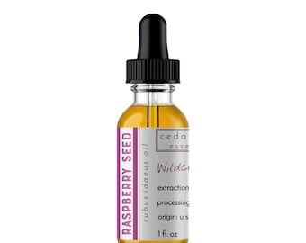 Può includere: Una bottiglia di vetro trasparente con un contagocce nero, contenente un liquido giallo. L'etichetta è bianca con testo rosa che dice "RASPBERRY SEED rubus idaeus oil ceda esse Wilde extraction processing origin: u s 1 fl. oz"