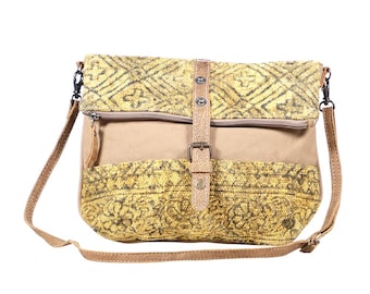 Può includere: Borsa a tracolla beige e gialla con chiusura a patta. La borsa presenta un tessuto giallo fantasia sulla patta e sul fondo, con un corpo in tela beige. Ha un cinturino e una fibbia in pelle marrone e una tasca con cerniera.