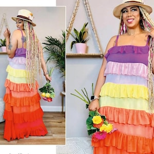 May include: A colorful, tiered maxi dress in shades of purple, pink, yellow, orange, and red. The dress features a ruffled design and spaghetti straps. The image also includes the text "THE CORNY RAINBOW knowME by mimi g" and a QR code.