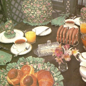 May include: A vintage Vogue Patterns craft pattern for a teapot cozy, featuring a floral print and a green and white trim. The pattern number is 8316 and the price is $4.00.