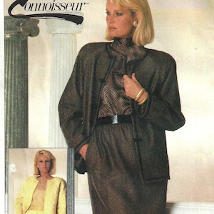 May include: Simplicity Connoisseur Collection sewing pattern. The image shows a woman wearing a brown skirt suit with a black belt. The pattern number is 7212, and the sizes are 10+12+14. The text "PATTERN/PATRON" is visible.