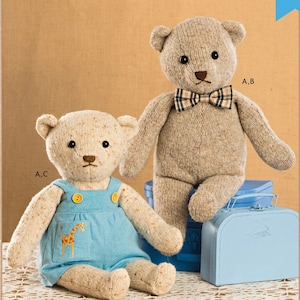 May include: Two stuffed teddy bears, one wearing blue overalls with a giraffe design and the other wearing a plaid bow tie. The bears are sitting on a white crocheted tablecloth with a blue suitcase in the background. The image includes the text "Kwik Sew K4389" and "Stuffed Bear with Clothes".